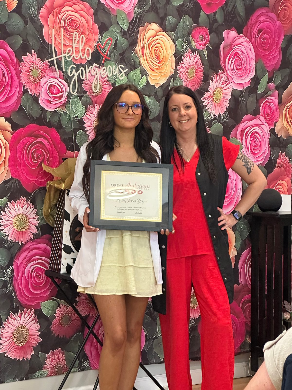 A Great Ambitions graduate holding her certificate with her instructor